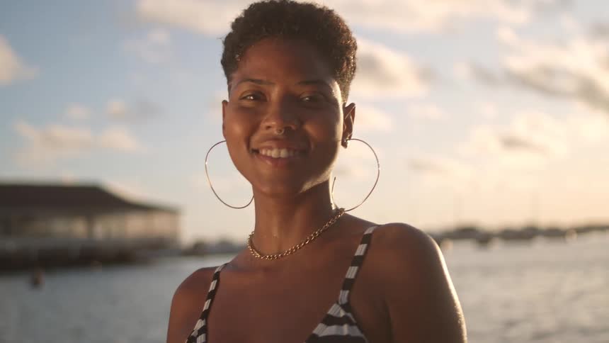 A woman is smiling by the lake