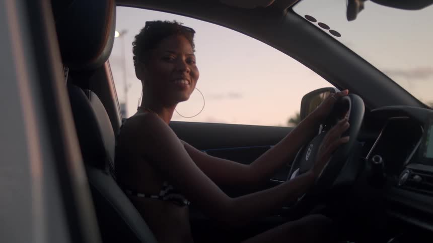 A woman smiles while sitting in the drivers seat