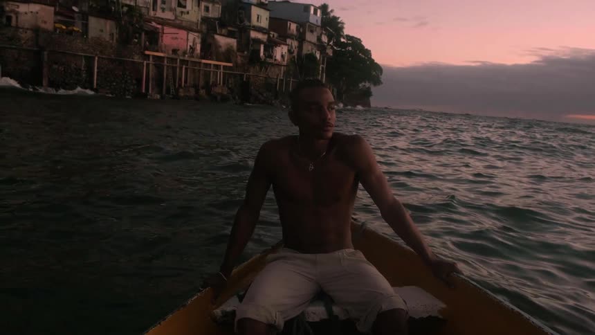 The man looks around while sitting in a row boat