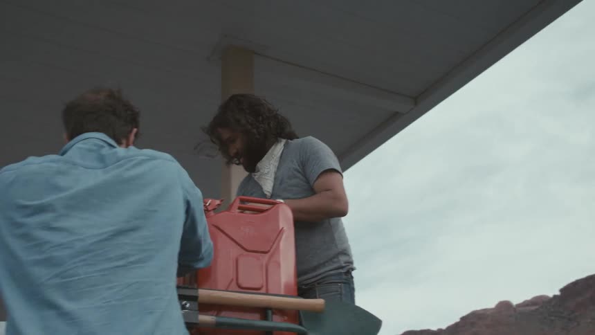 Men securing items to car roof