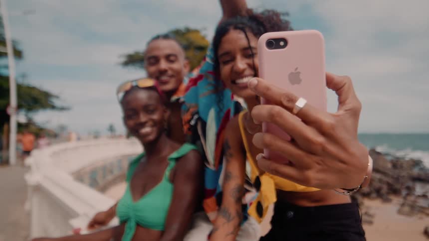Friends pose for a selfie on the beach