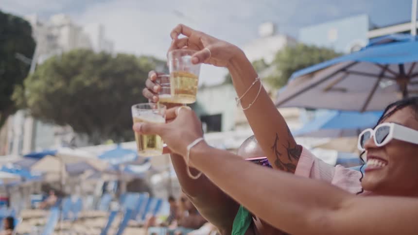 Friends are celebrating and toasting drinks together at the beach