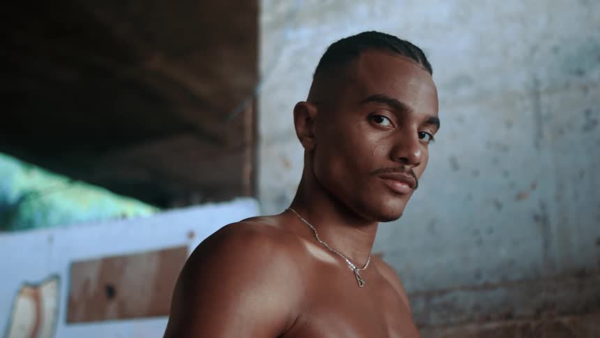 Close up portrait of a young black man standing indoors during daytime
