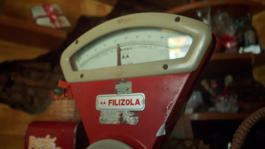 A vintage red and white metal scale in an antique store
