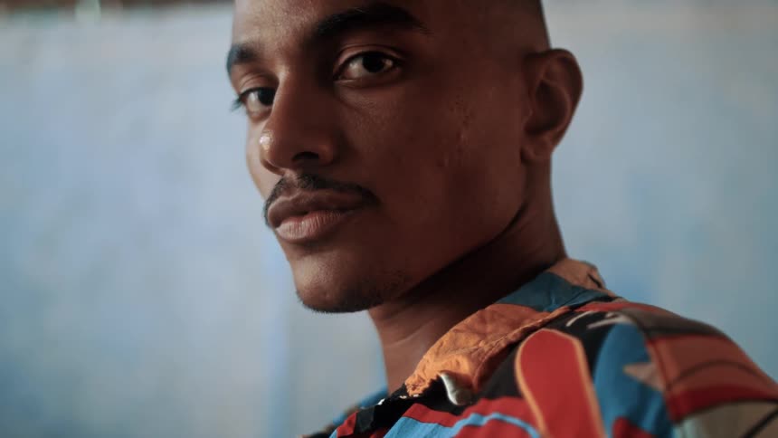 A young man with a mustache wearing summer clothing