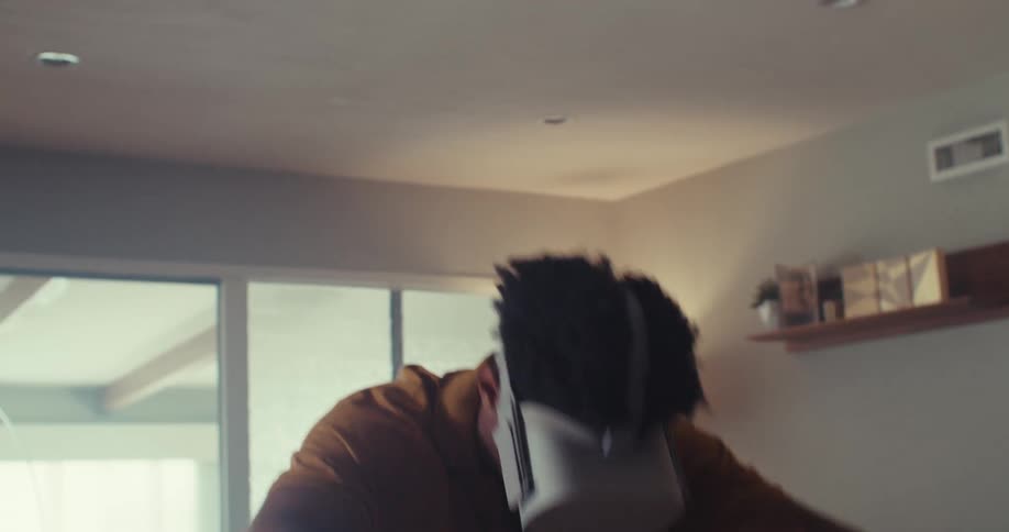 The man presses buttons on the controller