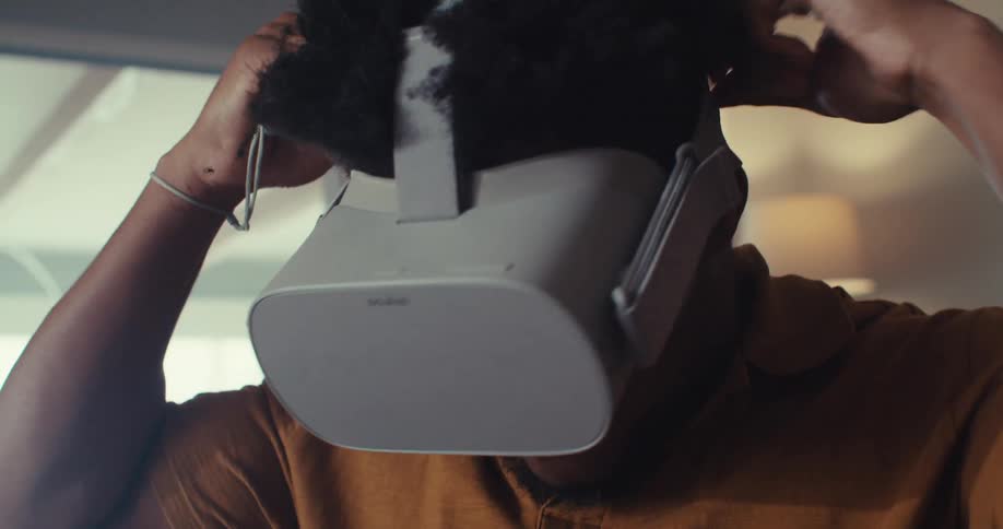 A man puts on a vr headset preparing to enter virtual reality