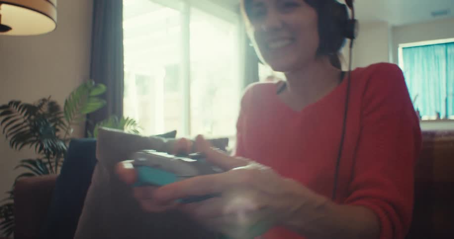 A woman cheers and raises her arms while playing video games