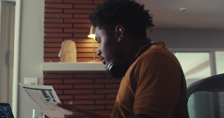 A man is reading paperwork at his desk