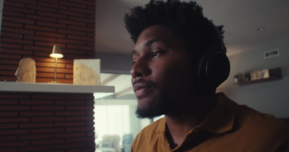A man talks while wearing headphones