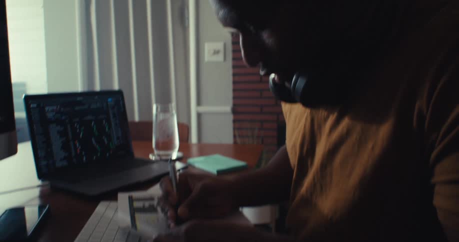 The man looks at a graph and writes something down