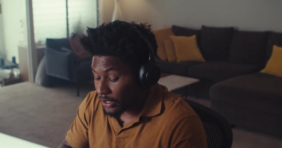 Man working remotely from home gestures while on a video call