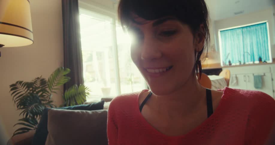 The woman lifts up the controller and laughs