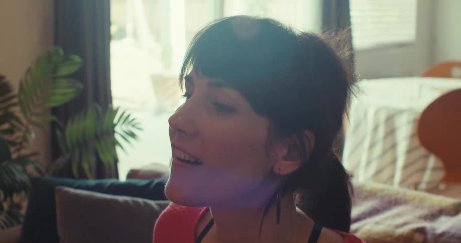 A woman reacts with joy after removing a vr headset in a sunlit living room
