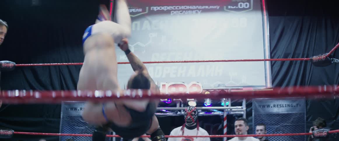 A wrestler is violently flipped as he fights in an arena