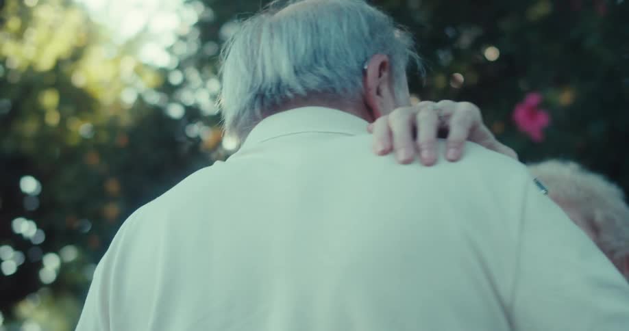An elderly couple dances
