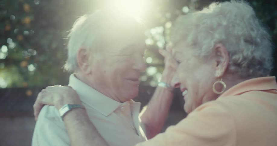 An elderly couple dances