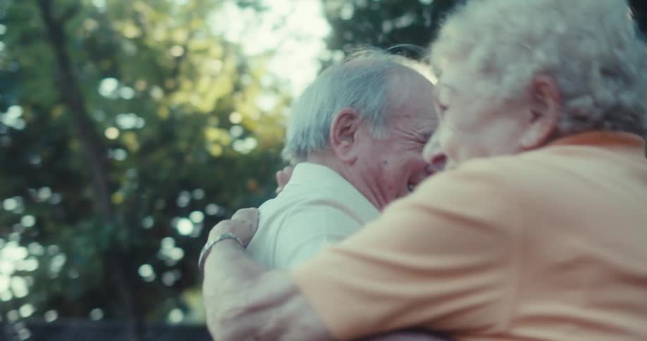 An elderly couple dances