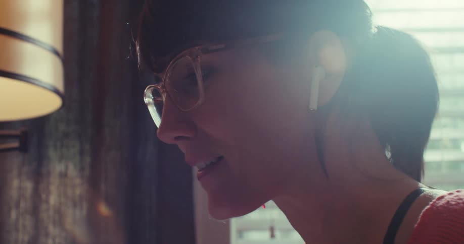 A woman talks while working on her tablet