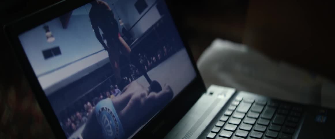 A wrestling match is playing on a laptop screen