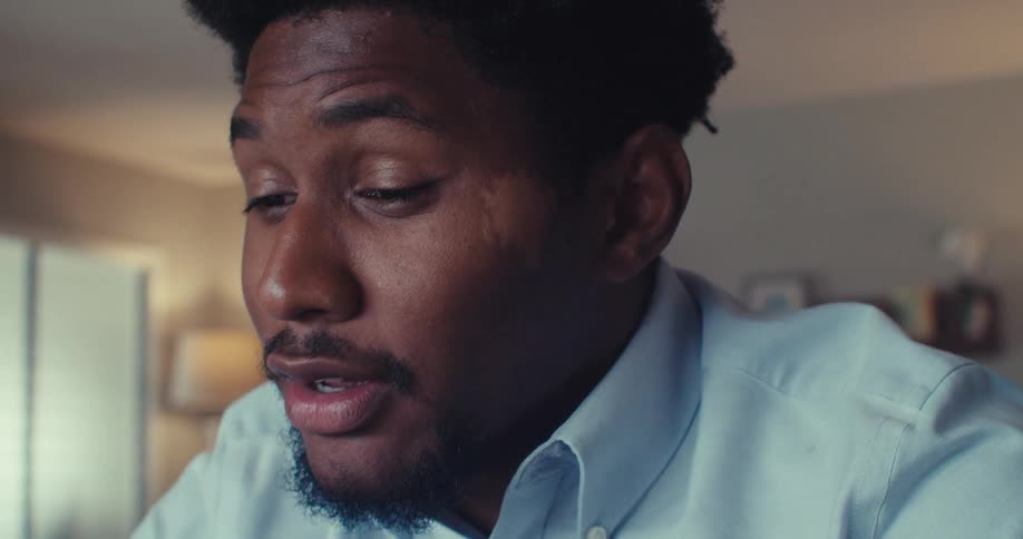 A man talks while wearing a blue shirt