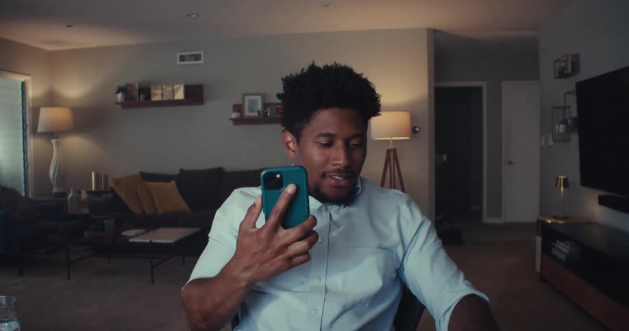 Man working at home stops to answer an enjoyable phone call before walking away