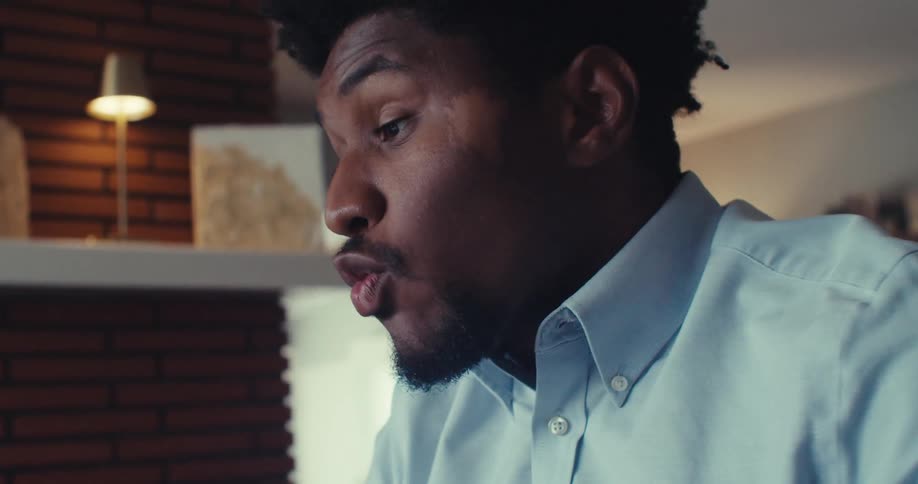 The face of a man who is talking and articulating his hands to the screen of a laptop