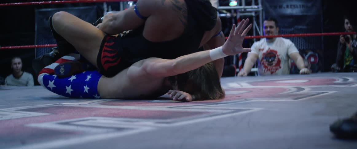 Two wrestlers are fighting in a ring