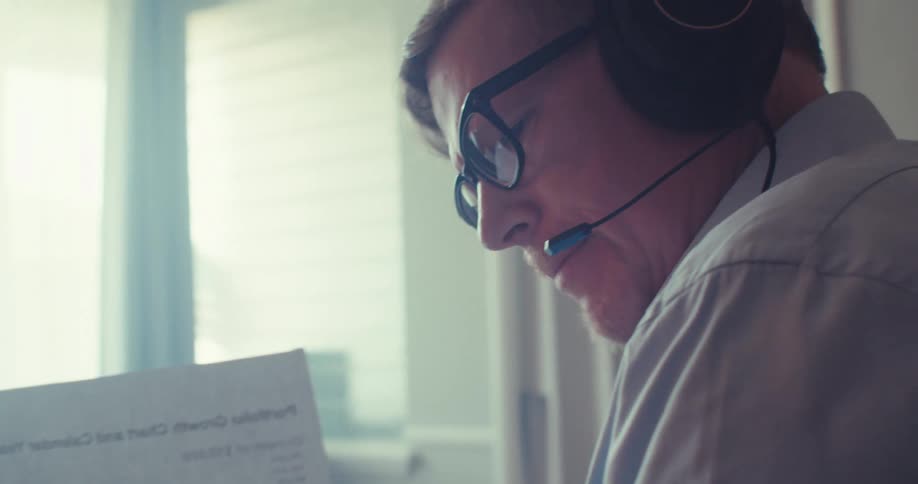 Man with headphones holding a document with data