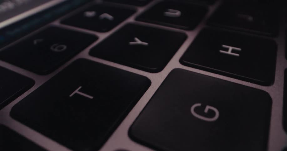 A finger types on a keyboard