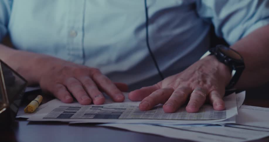 Man working at a desk arranges paperwork