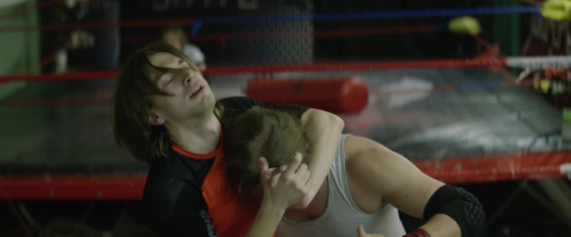 Two wrestlers practice holds in a ring