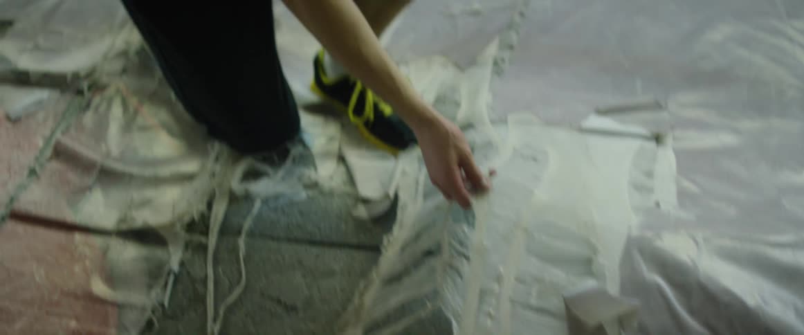 Man ripping up tattered floor covering