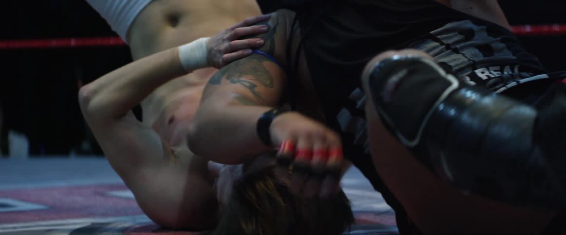 Two wrestlers are grappling on the ring