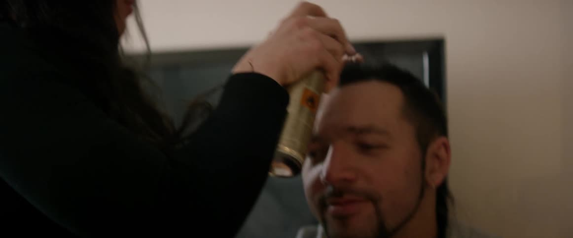 Woman styling a man's hair