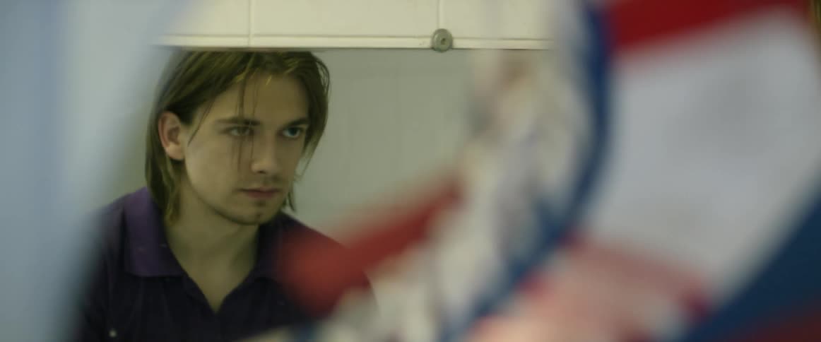 A man is looking into a mirror