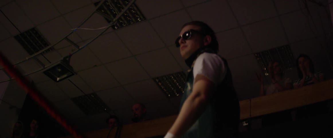 A wrestler climbs into a wrestling ring
