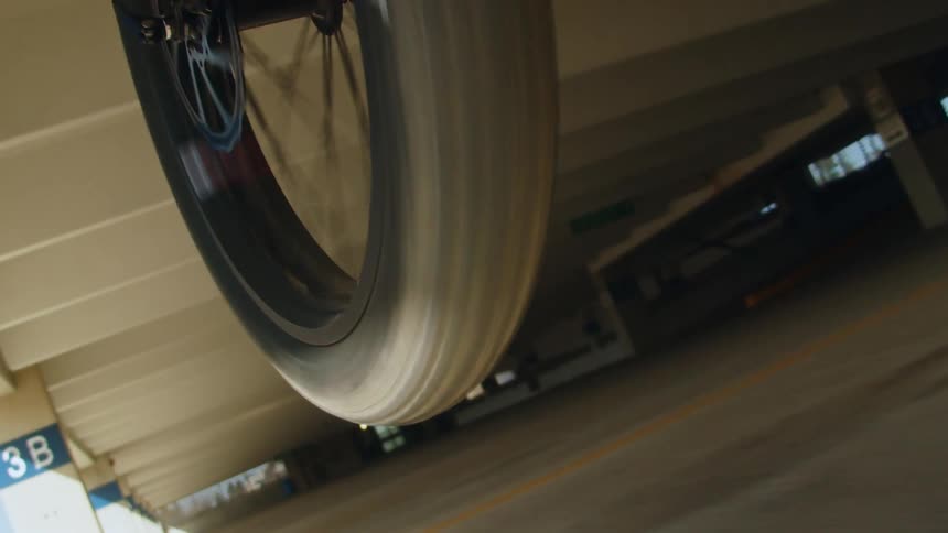 Bike wheel lifts off the ground as rider pops a wheelie.