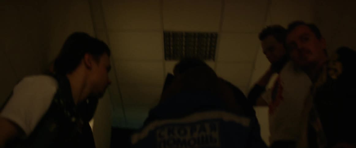 People walk down a long dark hall