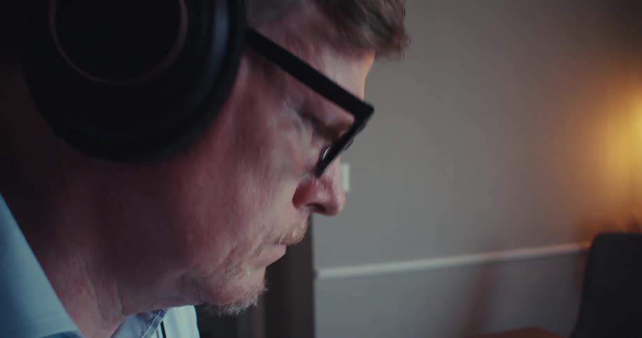 Man working in an office references data on two different computers