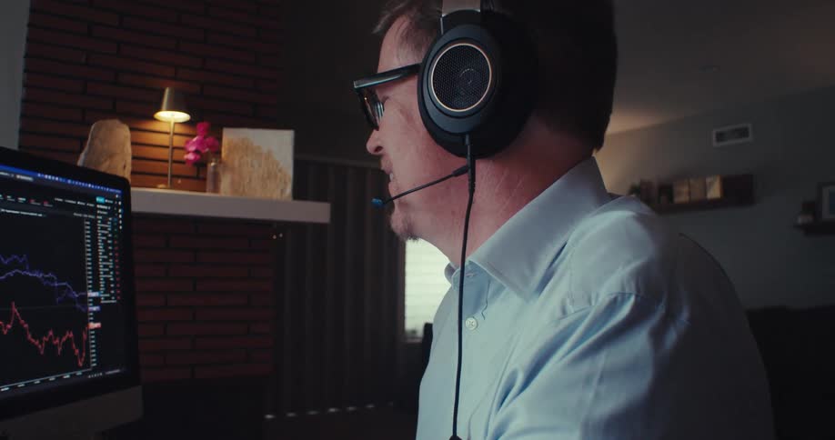A man talks into his headset while using a computer