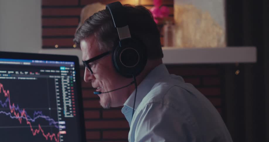 A man waves to his computer screen