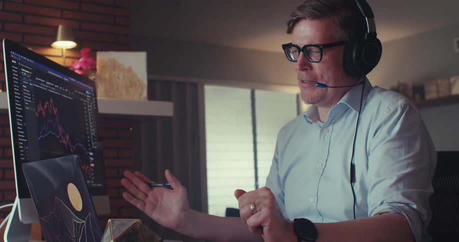 Man in headset on office call analyzing financial charts