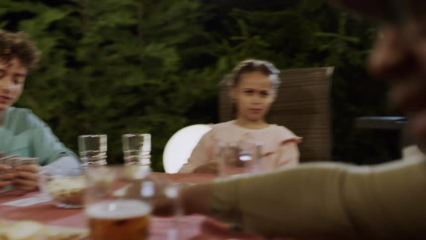 Young girl plays cards at an outdoor family gathering