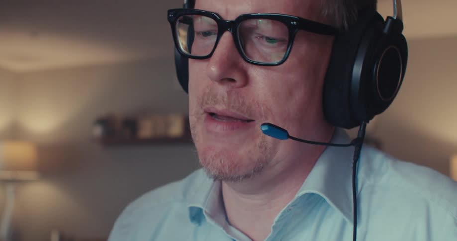 A man talks while looking at a tablet screen