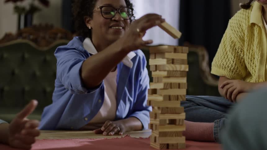 A family pull blocks out of the board game
