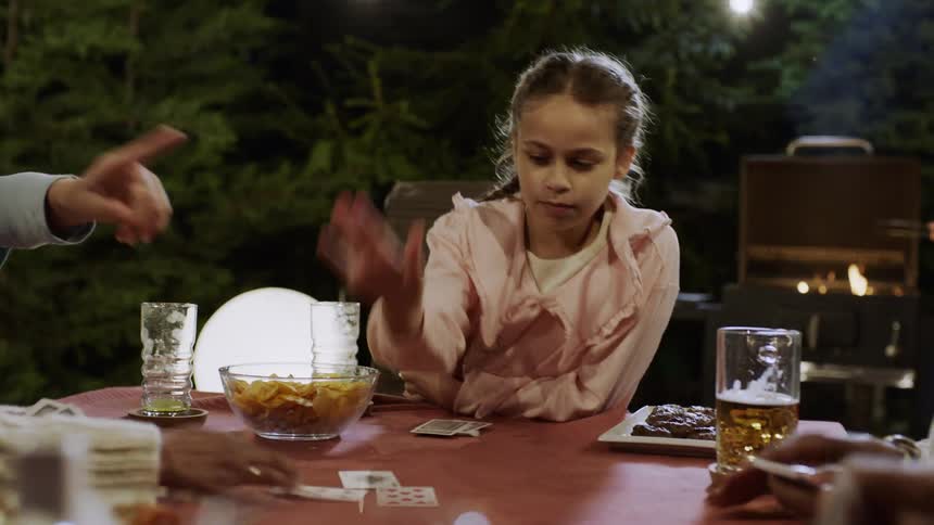 A family laugh as they play cards together