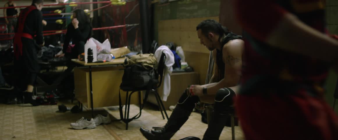 A wrestler is adjusting his knee pads
