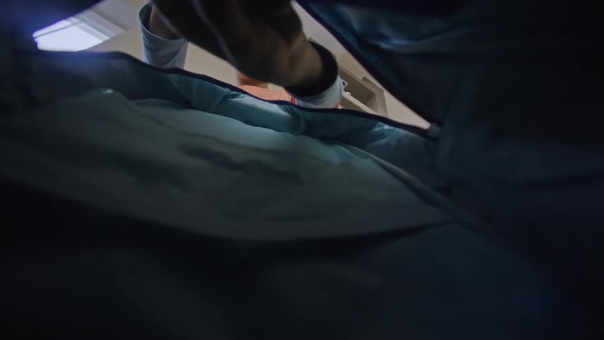 A boy empties a bag reaching in as seen from the perspective inside the bags opening