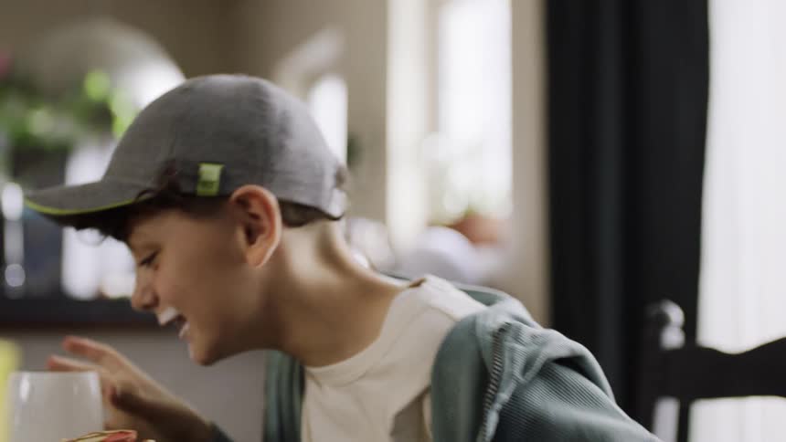 Two boys enjoy brunch together in a cozy welllit kitchen caf setting